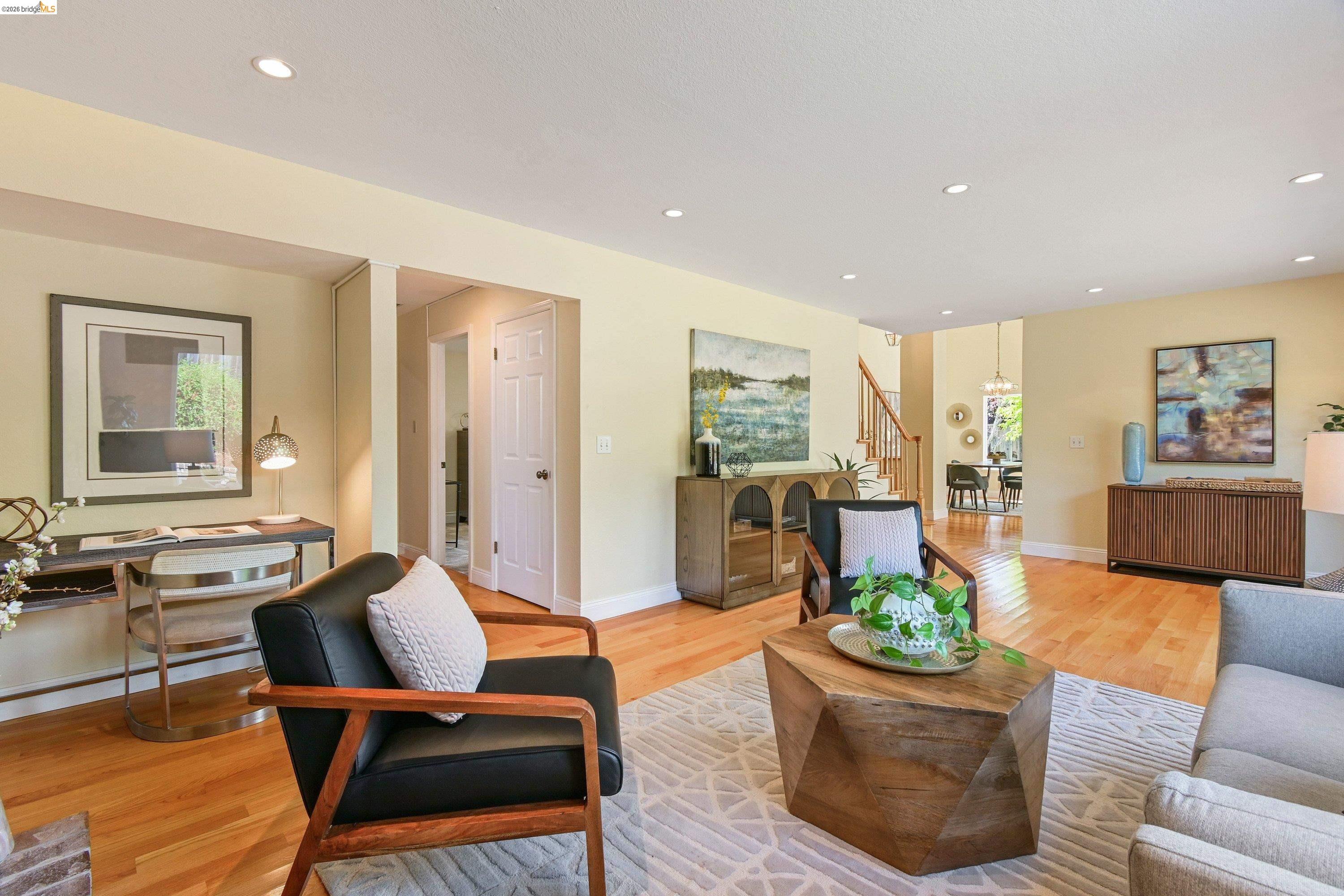 Formal living and dining flowing together under the vaulted ceiling, with the staircase to the upper bedrooms beyond